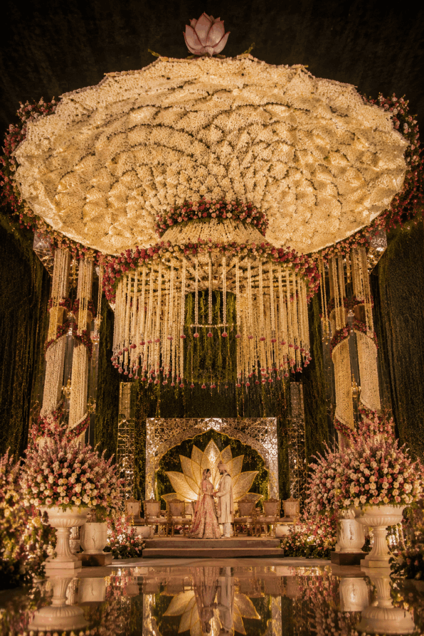 Spectacular thousand-petal floral mandap featuring an extraordinary luxury wedding installation with cascading flowers, grand floral ceiling, and elegant stage design for an ultra-luxury Indian destination wedding.